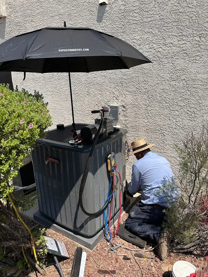 HVAC technician performing outdoor AC maintenance in Sahuarita