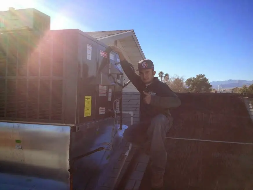 HVAC technician performing AC Tune-Up on a rooftop unit in Sahuarita